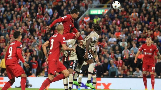 Momen bek Liverpool, Joel Matip (tengah atas) sebelum mencetak gol ke gawang Ajax pada laga Liga Champions di Anfield, Liverpool, Inggris, Rabu (14/9/2022) dini hari WIB. [Lindsey Parnaby / AFP]