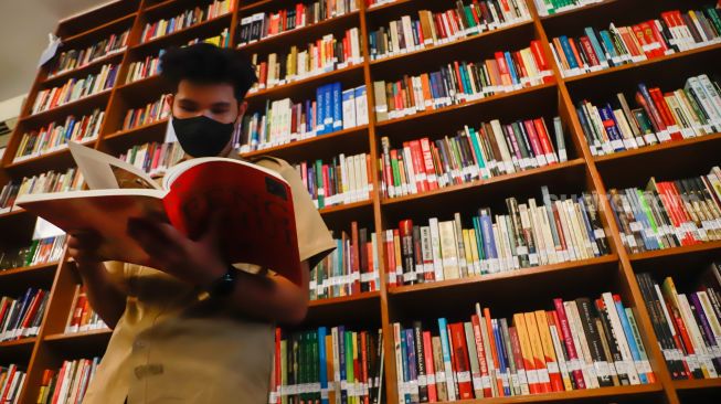 Pengunjung membaca buku di perpustakaan "Baca Di Tebet", Jakarta Selatan, Rabu (14/5/9/2022). [Suara.com/Alfian Winanto]