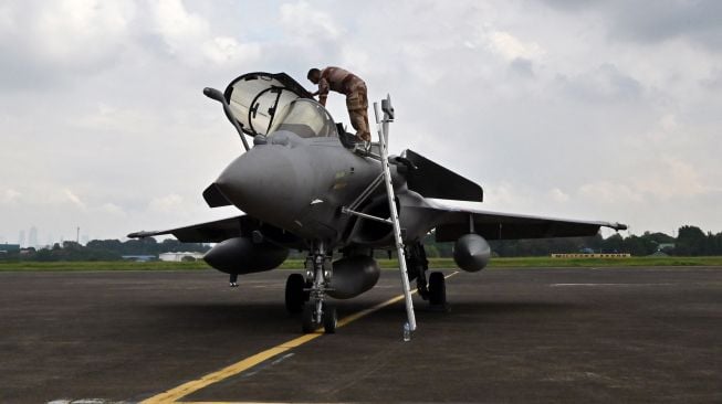 Personel Angkatan Udara Prancis bersiap menaiki pesawat tempur Multirole Dassault Rafale untuk demonstrasi penerbangan di Lanud Halim Perdanakusuma, Jakarta, Indonesia, Selasa (12/9/2022). [ADEK BERRY / AFP]