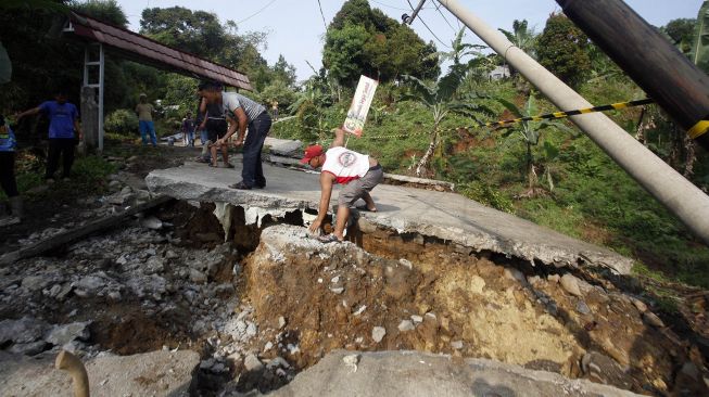 Kondisi jalan yang terbelah akibat pergerakan tanah di Bojong Koneng, Babakan Madang, Kabupaten Bogor, Jawa Barat, Jumat (16/9/2022).  ANTARA FOTO/Yulius Satria Wijaya