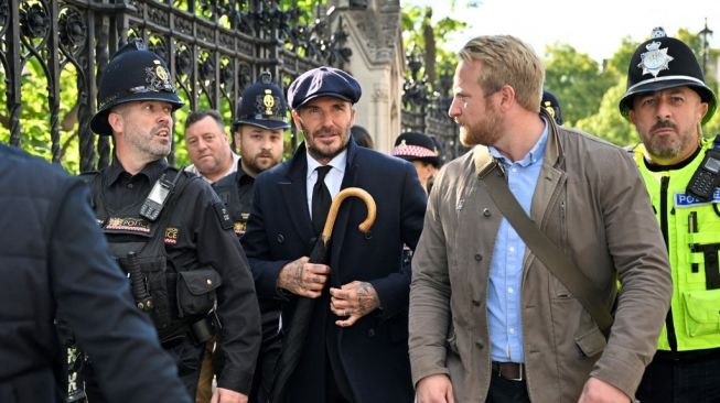 Mantan pesepak bola Inggris David Beckham meninggalkan Westminster Hall, di Istana Westminster, di London pada 16 September 2022 setelah memberikan penghormatan kepada mendiang Ratu Elizabeth II. Ratu Elizabeth II akan disemayamkan di Westminster Hall di dalam Istana Westminster, hingga pukul 05:30 GMT pada 19 September, beberapa jam sebelum pemakamannya, dengan antrean besar diperkirakan akan melewati peti matinya untuk memberi penghormatan.
Louisa Gouliamaki / AFP.