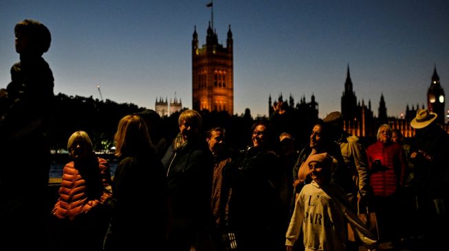 Masyarakat mengantri untuk memberi penghormatan kepada mendiang Ratu Elizabeth II yang terbaring di Westminster Hall, London, Inggris, Jumat (16/9/2022). [Louisa Gouliamaki / AFP]