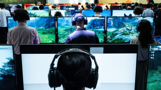 Pengunjung bermain video game saat acara Tokyo Game Show di prefektur Chiba, Tokyo, Jepang, Kamis (15/9/2022). [Yuichi YAMAZAKI/AFP]