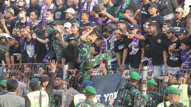 Petugas mengamankan suporter saat laga Liga 1 angara Persik Kediri melawan Arema FC di Stadion Brawijaya, Kota Kediri, Jawa Timur, Sabtu (17/9/2022). ANTARA FOTO/Prasetia Fauzani/aww.