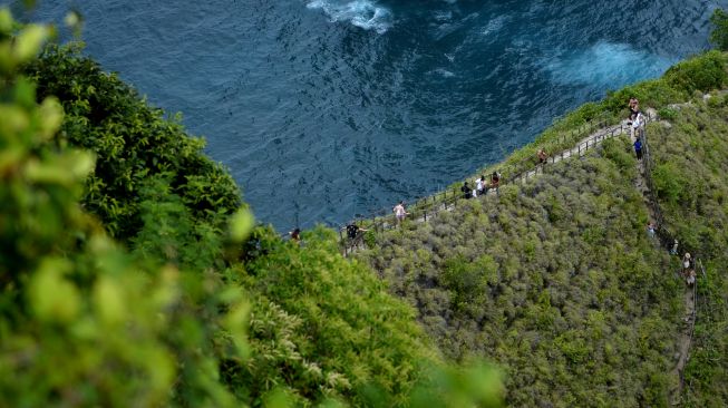 Wisatawan mengunjungi Pantai Kelingking, Nusa Penida, Klungkung, Bali, Sabtu (17/9/2022). [ANTARA FOTO/Fikri Yusuf/aww]