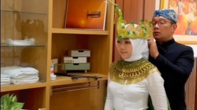 Ridwan Kamil membantu sang istri, Athalia Praratya mengenakan gaun tari. [Instagram]