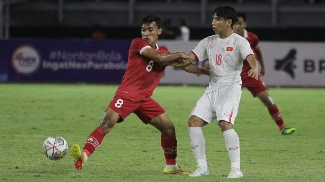 Pesepak bola Indonesia Arkhan Fikri (kiri) berebut bola dengan pesepak bola Vietnam Dinh Xuan Tien (kanan) saat pertandingan babak kualifikasi Piala Asia U-20 2023 Grup F di Stadion Gelora Bung Tomo, Surabaya, Jawa Timur, Minggu (18/9/2022). [ANTARA FOTO/Moch Asim/nz]