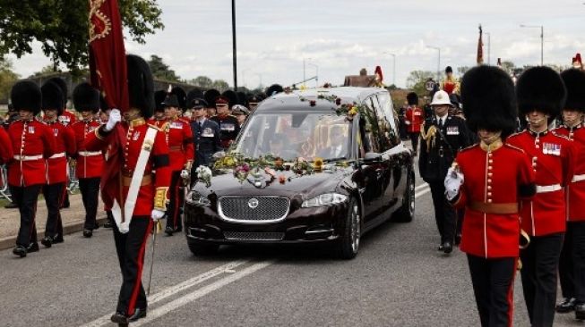 Peti jasad Ratu Elizabeth II di kereta merta State Hearse, tiba di The Long Walk sebelum memasuki Windsor Castle pada 19 September 2022, setelah prosesi pelepasan secara kenegaraan di London beberapa saat sebelumnya [AFP/POOL/Carlos Jasso].