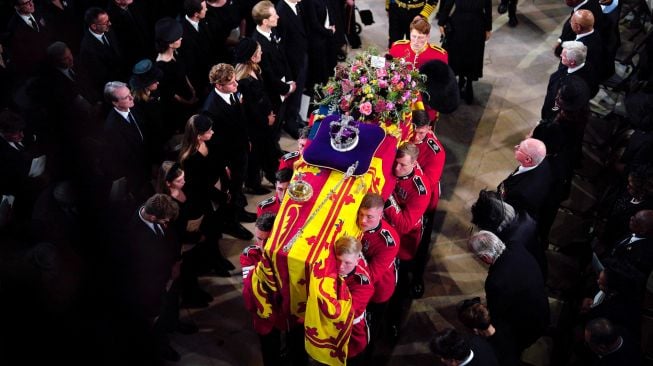 Prajurit kerajaan membawa peti mati Ratu Elizabeth II saat prosesi pemakaman di Kapel St George yang ada di dalam Kastil Windsor, Inggris, Senin (19/9/2022). [Ben Birchall / POOL / AFP]