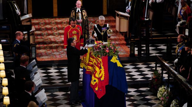 Anggota keluarga kerajaan menyaksikan Mahkota Kerajaan diambil dari atas peti mati saat prosesi pemakaman Ratu Inggris Elizabeth II di Kapel St George yang ada di dalam Kastil Windsor, Inggris, Senin (19/9/2022). [Ben Birchall / POOL / AFP]