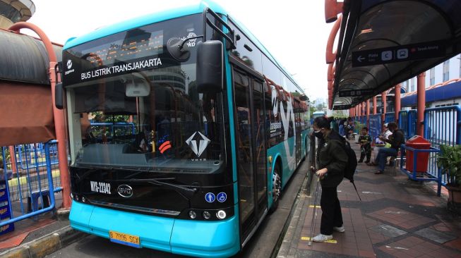 Warga bersiap menaiki Bus Listrik Transjakarta di Terminal Blok M, Jakarta, Selasa (20/9/2022). [NTARA FOTO/Reno Esnir/tom].