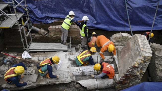 Sejumlah pekerja berusaha membersihkan terakota berupa saluran air yang berada di proyek pembangunan jalur MRT Jakarta fase 2 CP-203 di kawasan Glodok, Jakarta Barat, Selasa (20/9/2022).[ANTARA FOTO/M Risyal Hidayat/foc].