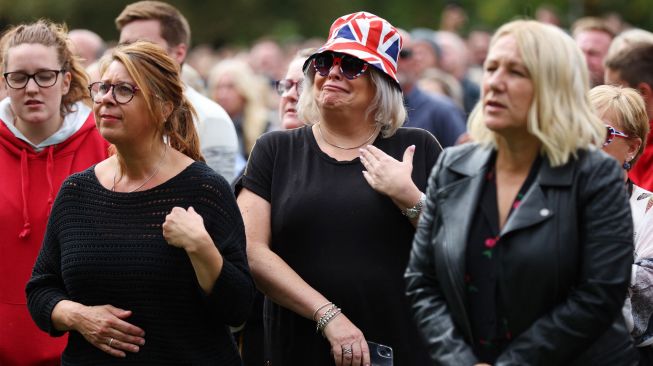 Warga Inggris menyaksikan iring-iringan yang membawa peti mati Ratu elizabeth II saat tiba di Kastil Windsor, Inggris, Senin (19/9/2022). [Alex Pantling / POOL / AFP]