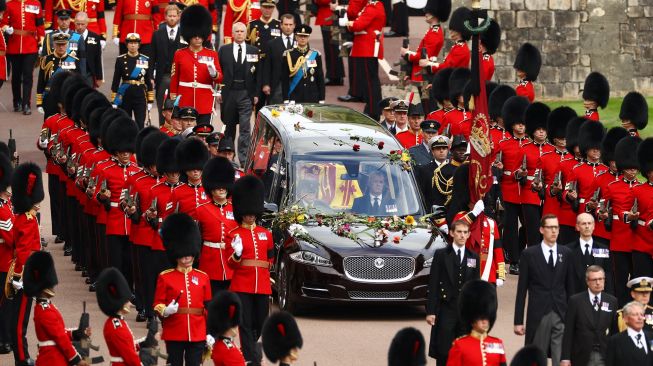 Prajurit kerajaan mengawal iring-iringan yang membawa peti mati Ratu elizabeth II saat tiba di Kastil Windsor, Inggris, Senin (19/9/2022). [Ryan Pierse / POOL / AFP]