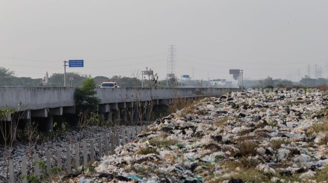 Penampakan Tempat Pembuangan Sampah (TPS) liar di bantaran Kali CBL (Cikarang Bekasi Laut) di Tambun, Kabupaten Bekasi, Jawa Barat, Rabu (21/9/2022). [Suara.com/Alfian Winanto]