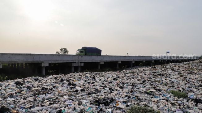 Penampakan Tempat Pembuangan Sampah (TPS) liar di bantaran Kali CBL (Cikarang Bekasi Laut) di Tambun, Kabupaten Bekasi, Jawa Barat, Rabu (21/9/2022). [Suara.com/Alfian Winanto]