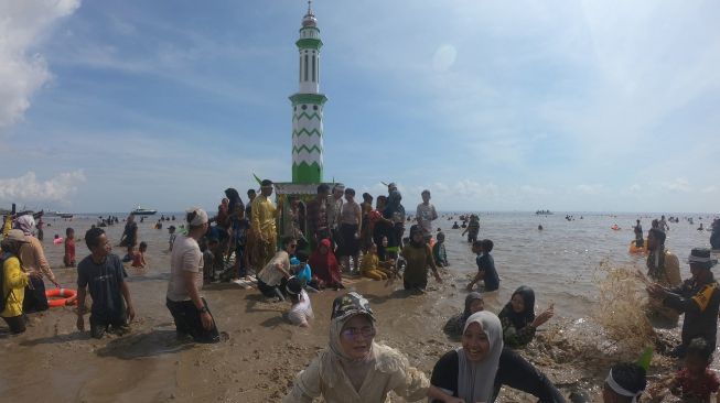 Sejumlah warga saling siram saat pelaksanaan Tradisi Mandi Safar 2022 di Pantai Babussalam, Tanjungjabung Timur, Jambi, Rabu (21/9/2022). [ANTARA FOTO/Wahdi Septiawan/nym].