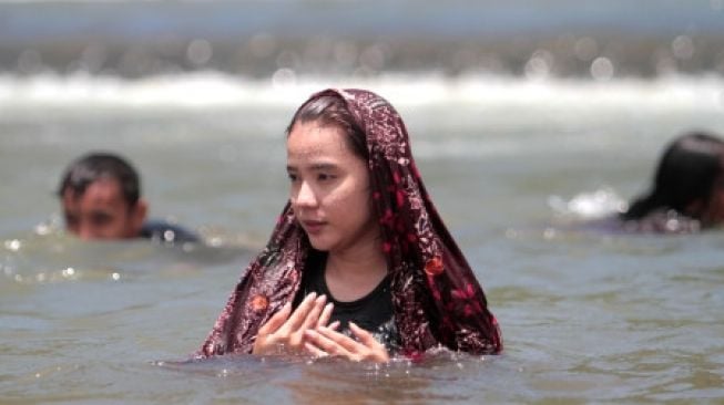 Seorang warga mengikuti tradisi Mandi Safar di Desa Buata, Kabupaten Gorontalo Utara, Gorontalo, Rabu (21/9/2022). [ANTARA FOTO/Adiwinata Solihin/nz]