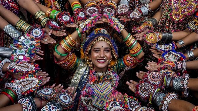 Peserta dari kelompok seni mengenakan pakaian tradisional berlatih tari Garba menjelang festival Navratri di Ahmedabad, India, Selasa (20/9/2022). [SAM PANTHAKY / AFP]
