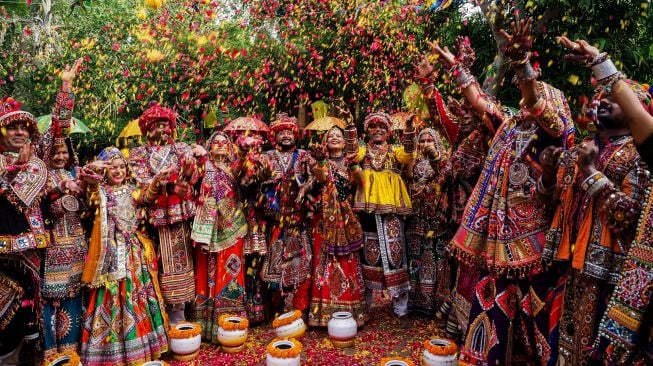 Peserta dari kelompok seni mengenakan pakaian tradisional berlatih tari Garba menjelang festival Navratri di Ahmedabad, India, Selasa (20/9/2022). [SAM PANTHAKY / AFP]
