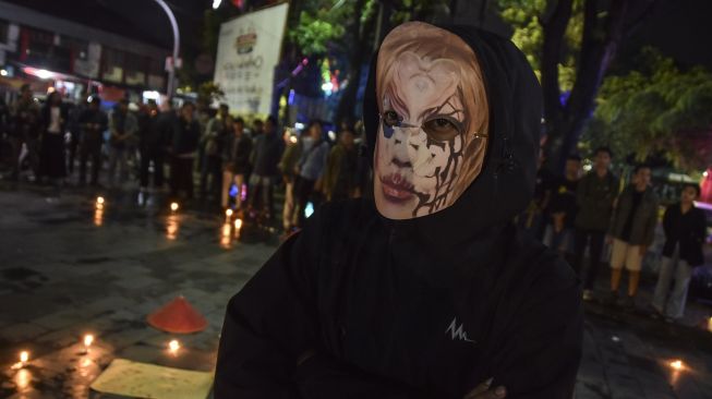 Mahasiswa memakai topeng Bjorka saat mengikuti aksi teaterikal sambil menyalakan lilin di Taman Kota Tasikmalaya, Jawa Barat, Rabu (21/9/2022) malam.  ANTARA FOTO/Adeng Bustomi
