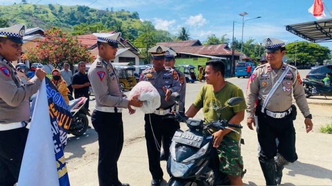 Satlantas Polres Gorontalo Utara bagikan helm gratis  dalam rangka HUT ke-67 Lalu Lintas Bhayangkara di Gorontalo, simak pengguna sepeda motor yang tidak menggunakan pelindung kepala [ANTARA/Susanti Sako].