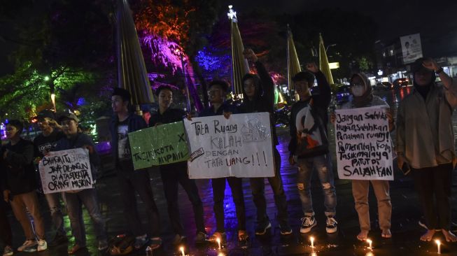 Mahasiswa yang tergabung gerakan Tasik Kelabu menggelar aksi teaterikal sambil menyalakan lilin di Taman Kota Tasikmalaya, Jawa Barat, Rabu (21/9/2022) malam. ANTARA FOTO/Adeng Bustomi
