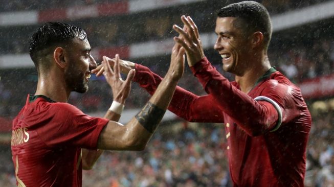 Dua pemain Timnas Portugal, Cristiano Ronaldo (kanan) dan Bruno Fernandes. [JOSE MANUEL RIBEIRO / AFP]