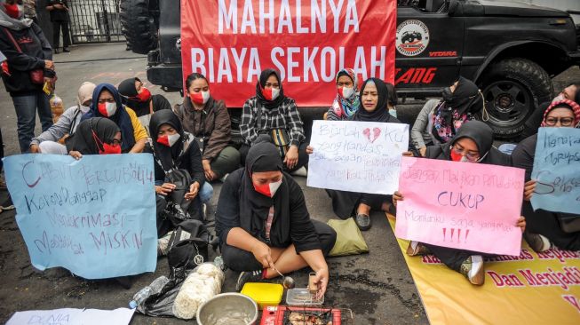 Massa dari Forum Masyarakat Peduli Pendidikan Jawa Barat memasak ikan asin saat aksi tolak mahalnya biaya sekolah di Gedung DPRD Jabar, Bandung, Jawa Barat, Kamis (22/9/2022). [ANTARA FOTO/Raisan Al Farisi/rwa].