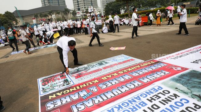 Massa yang tergabung dalam Forum Komunikasi Honorer Nakes & Non Nakes (FKHN) Indonesia melalukan aksi unjuk rasa di kawasan Patung Kuda, Monas, Jakarta Pusat, Kamis (22/9/2022). [Suara.com/Alfian Winanto]