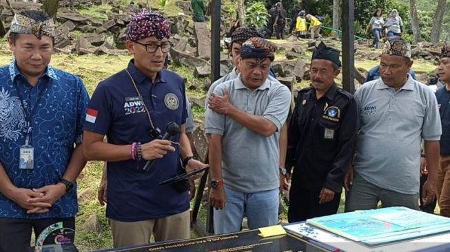 Menteri Pariwisata dan Ekonomi Kreatif (Menparekraf) Sandiaga Salahuddin Uno, memberikan Anugerah Desa Wisata Terbaik untuk Situs Meghalit Gunung Padang, didampingi Kadisbudpar Cianjur, Jawa Barat, Pratama Nugraha, Kamis (22/9/2022). [ANTARA/Ahmad Fikri]