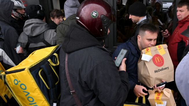 Kurir pengiriman makanan Glovo mengambil pesanan di sebuah restoran McDonald di Kyiv, Ukraina, Selasa (20/9/2022). [Sergei SUPINSKY / AFP]