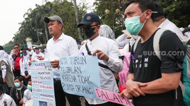 Massa yang tergabung dalam Forum Komunikasi Honorer Nakes & Non Nakes (FKHN) Indonesia melalukan aksi unjuk rasa di kawasan Patung Kuda, Monas, Jakarta Pusat, Kamis (22/9/2022). [Suara.com/Alfian Winanto]