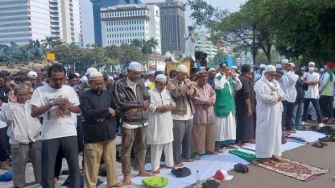 Hentikan Aksi Sementara, Massa Aksi GNPR Tunaikan Ibadah Salat Berjemaah di Kawasan Patung Kuda