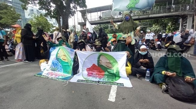 Massa aksi dari kalangan emak-emak yang ikut turun ke jalan bersama Gerakan Nasional Pembela Rakyat (GNPR) di kawasan Patung Kuda, Jakarta Pusat, Jumat (23/9/2022) siang turut membawa peralatan masak. (Suara.com/ Yosea Arga)