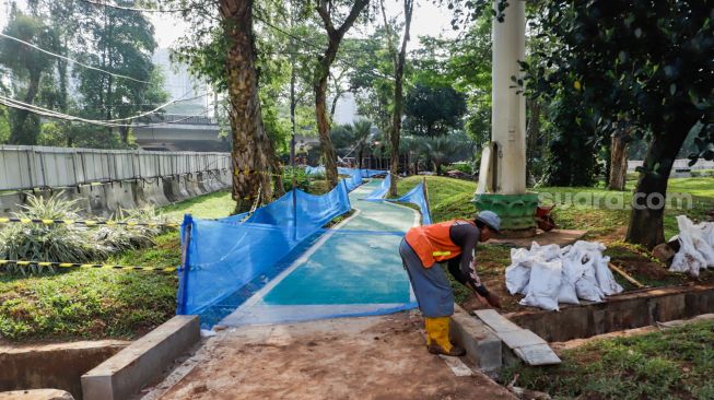 Pekerja menyelesaikan pembangunan jalur sepeda di kawasan Semanggi, Jakarta Pusat, Sabtu (24/9/2022). [Suara.com/Alfian Winanto]