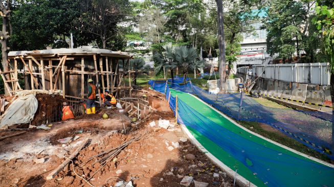 Pekerja menyelesaikan pembangunan jalur sepeda di kawasan Semanggi, Jakarta Pusat, Sabtu (24/9/2022). [Suara.com/Alfian Winanto]