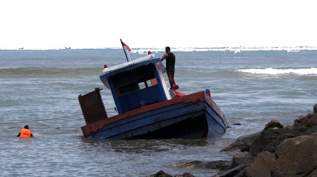 Sejumlah tim SAR bersama warga berupaya mengevakuasi kapal kayu angkutan penumpang dan barang KM Satria Pulo Breuh yang mengalami karam di Pantai Wisata Gampong Jawa, Banda Aceh, Aceh, Sabtu (24/9/2022). [ANTARA FOTO/Irwansyah Putra/YU]