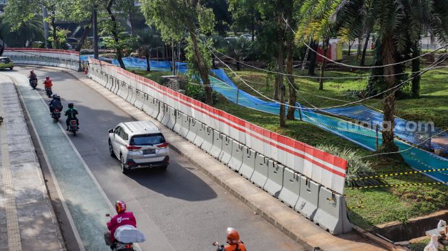 Kendaraan melintas di dekat pembangunan jalur sepeda di kawasan Semanggi, Jakarta Pusat, Sabtu (24/9/2022). [Suara.com/Alfian Winanto]