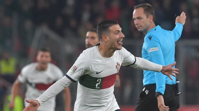 Bek sayap Timnas Portugal, Diogo Dalot melakukan selebrasi usai mencetak gol ke gawang Timnas Republik Ceko pada laga UEFA Nations League, Minggu (25/9/2022). [Michal Cizek / AFP]