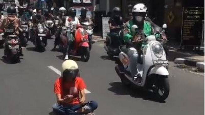 Pria Berbaju Merah Viral Karena Duduk Bersila di Jalanan Denpasar Hingga Sebabkan Macet