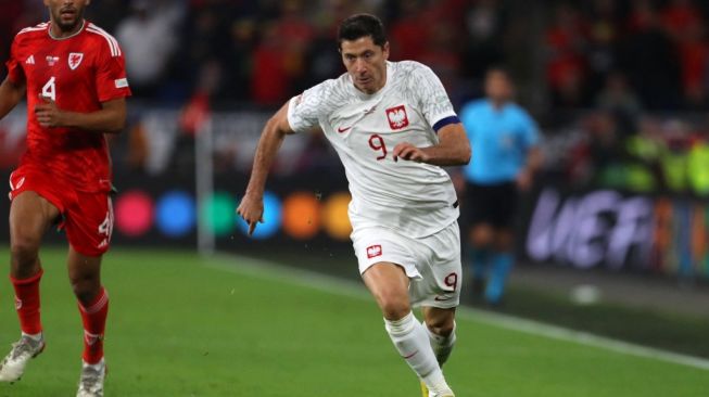 Striker Timnas Polandia Robert Lewandowski menggiring bola selama matchday keenam atau terakhir Grup A4 UEFA Nations League 2022-2023 antara Wales vs Polandia di stadion Cardiff City di Cardiff, Wales selatan pada 25 September 2022.Geoff Caddick / AFP.