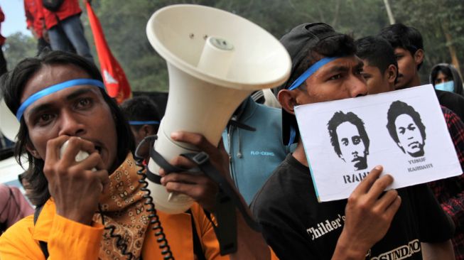 Mahasiswa berorasi dan memegang poster foto almarhum Randi dan Yusuf saat unjuk rasa mengenang kematian dua mahasiswa tersebut di Mapolda Sulawesi Tenggara, Kendari, Sulawesi Tenggara, Senin (26/9/2022). [ANTARA FOTO/Jojon/tom].