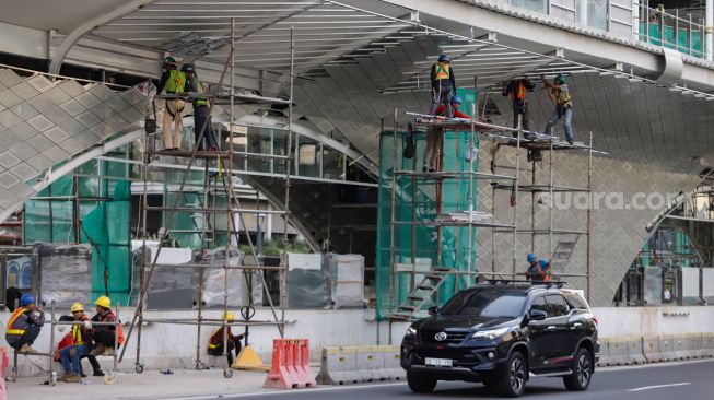 Pekerja menyelesaikan proyek revitalisasi Halte Transjakarta di Kawasan Bundaran HI, Jakarta Pusat, Selasa (27/9/2022). [Suara.com/Alfian Winanto]