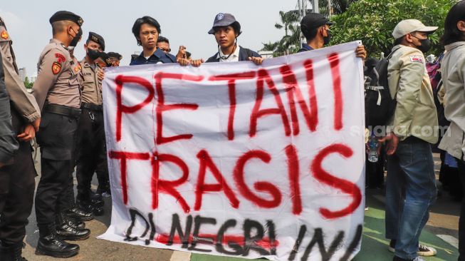 Massa gabungan dari Petani, Buruh dan Mahasiswa menggelar aksi unjuk rasa di depan Gedung DPR RI, Jakarta Pusat, Selasa (27/9/2022). [Suara.com/Alfian Winanto]