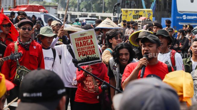 Massa gabungan dari Petani, Buruh dan Mahasiswa menggelar aksi unjuk rasa di depan Gedung DPR RI, Jakarta Pusat, Selasa (27/9/2022). [Suara.com/Alfian Winanto]