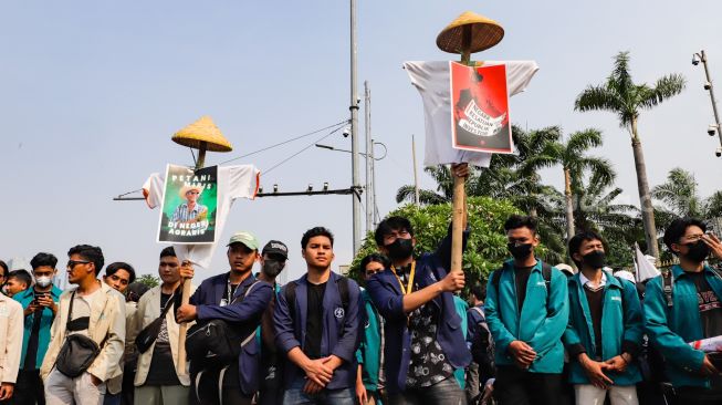 Massa gabungan dari Petani, Buruh dan Mahasiswa menggelar aksi unjuk rasa di depan Gedung DPR RI, Jakarta Pusat, Selasa (27/9/2022). [Suara.com/Alfian Winanto]