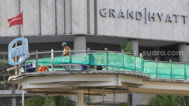 Pekerja menyelesaikan proyek revitalisasi Halte Transjakarta di Kawasan Bundaran HI, Jakarta Pusat, Selasa (27/9/2022). [Suara.com/Alfian Winanto]