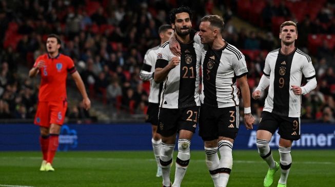 Bek Timnas Inggris Harry Maguire (kiri) bereaksi ketika gelandang Jerman Ilkay Gundogan (tengah) mencetak gol pembuka dari titik penalti selama matchday keenam Grup A3 UEFA Nations League antara Inggris vs Jerman di stadion Wembley di London utara pada 26 September 2022. Ben Stansall / AFP.
