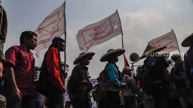 Massa gabungan dari Petani, Buruh dan Mahasiswa menggelar aksi unjuk rasa di depan Gedung DPR RI, Jakarta Pusat, Selasa (27/9/2022). [Suara.com/Alfian Winanto]